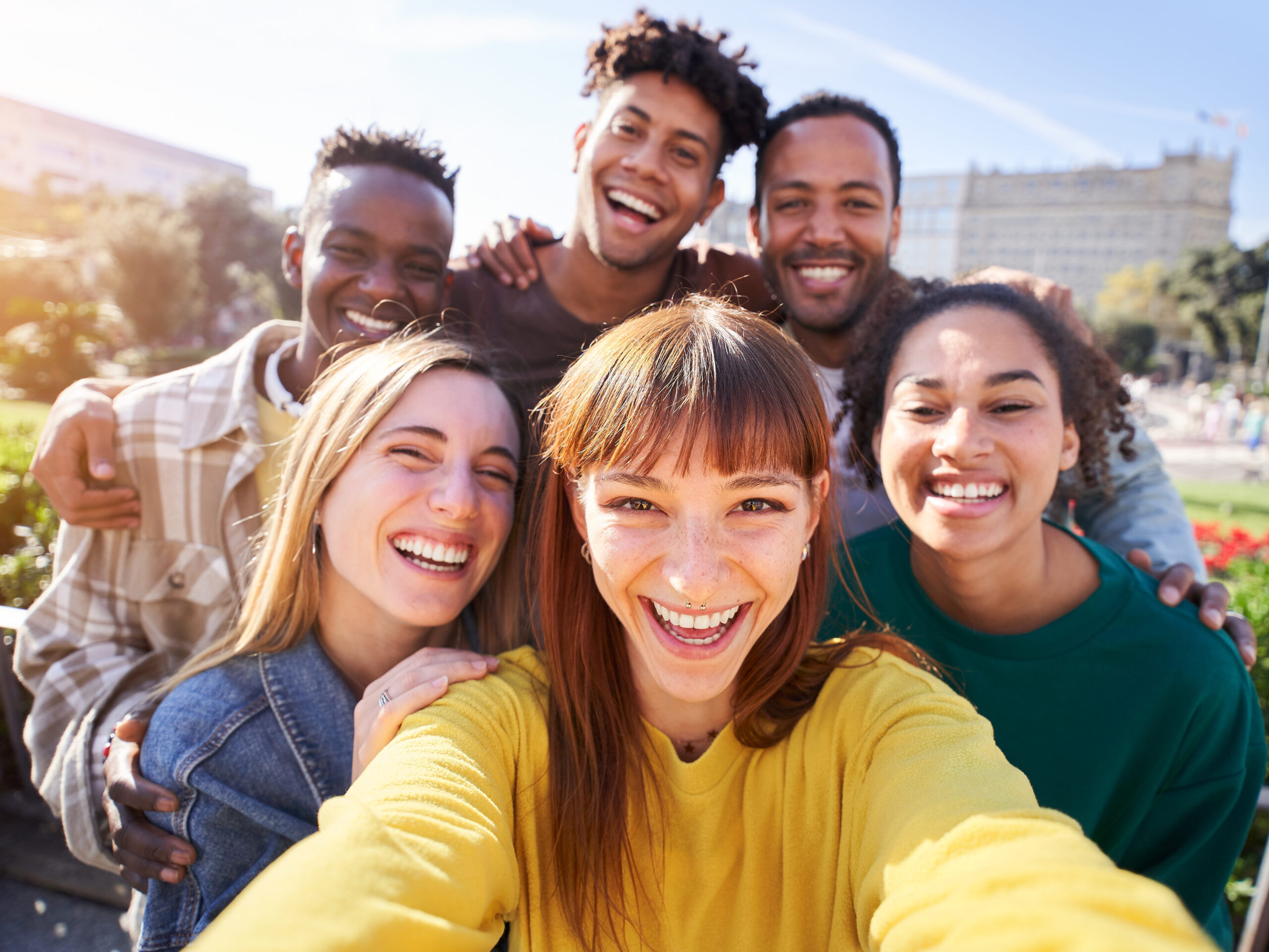 Gruppe von glücklichen Freunden, die an einem Frühlingstag für ein Selfie posieren, während sie gemeinsam im Freien feiern. Eine Gruppe multikultureller Freunde, die am Wochenende eine gute Zeit miteinander verbringen.