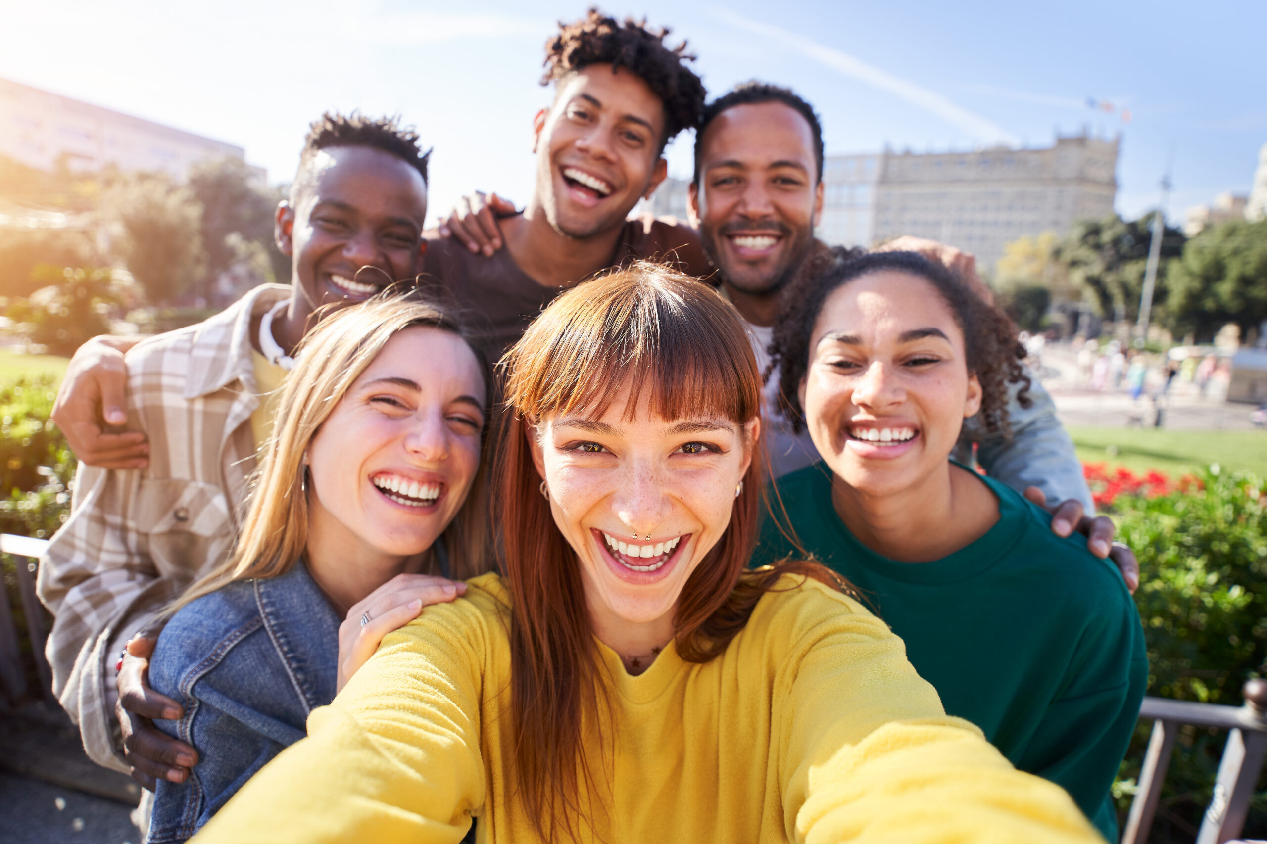 Gruppe von glücklichen Freunden, die an einem Frühlingstag für ein Selfie posieren, während sie gemeinsam im Freien feiern. Eine Gruppe multikultureller Freunde, die am Wochenende eine gute Zeit miteinander verbringen.